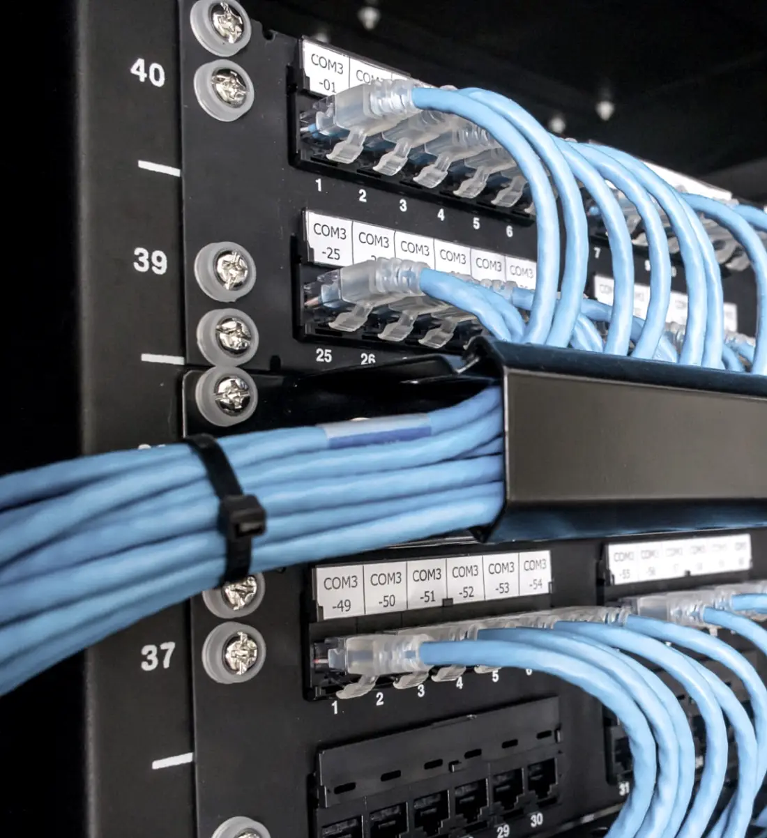 Panneaux de brassage repérés port par port, cordons dressés et peignés dans un rack étiqueté.
